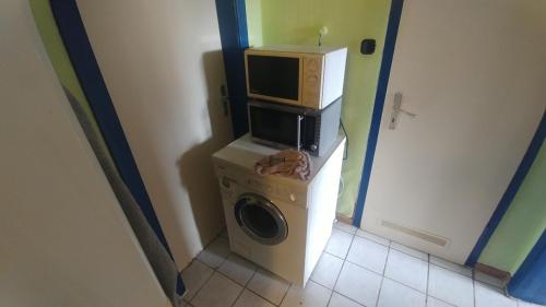 a washing machine with a microwave on top of it at SCHLAFGELEGENHEiT in Essen
