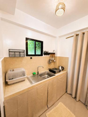 a kitchen with a sink and a window at A&H Homestay in Catangnan
