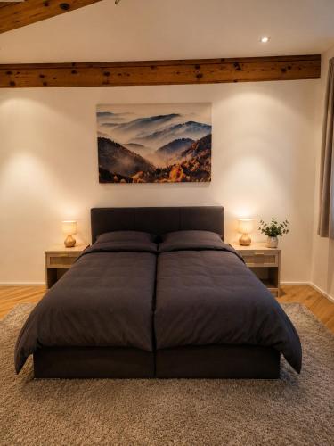 a bedroom with a large bed and two night stands at Bachchalet im Schwarzwald in Sasbachwalden