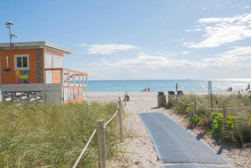 a beach with a building and a path to the beach at Charming Studio by the Ocean Beach Service in Hallandale Beach
