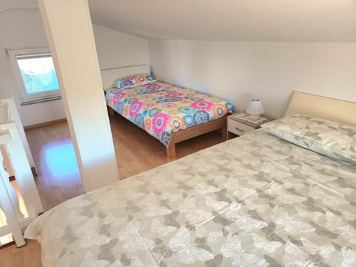 a small bedroom with a bed and a window at House Barizoni in Ankaran