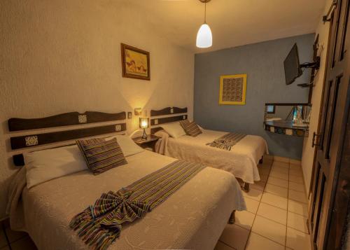 a hotel room with two beds in a room at Hotel Tepeyac in San Cristóbal de Las Casas