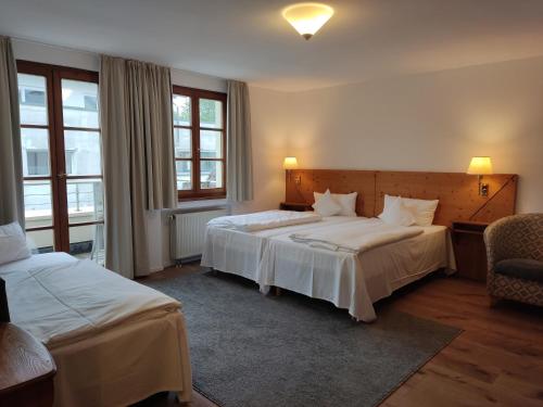 a hotel room with two beds and two windows at Hotel Restaurant Adler in Aalen