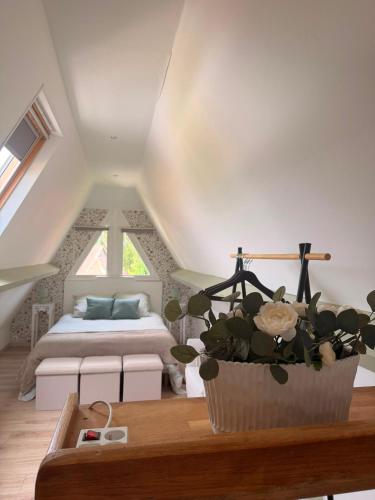 a bedroom with a bed and a table with a potted plant at La maisonnette in Forêt-la-Folie