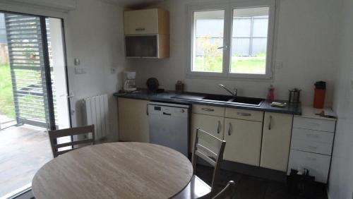 a kitchen with a table and a table and a sink at Pinede in Labenne
