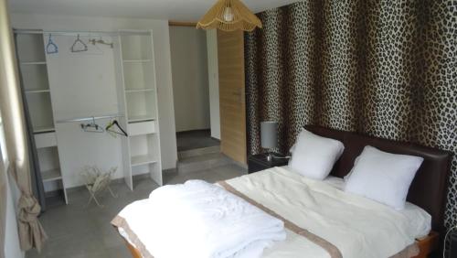a bedroom with a bed with white sheets and pillows at Pinede in Labenne