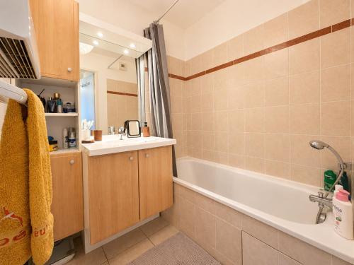 a bathroom with a bath tub and a sink at " Régussol Coloré " Piscine - Linge fourni - Wifi in Castelnau-dʼEstrétefonds