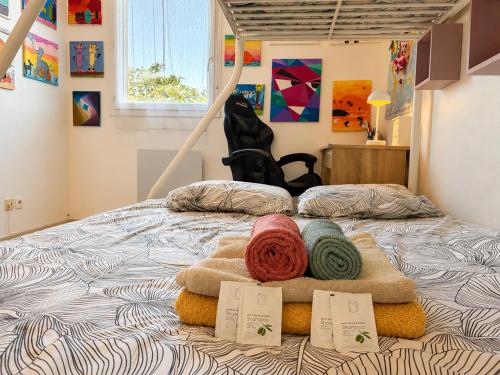 a bed with two balls of yarn on it at " Régussol Coloré " Piscine - Linge fourni - Wifi in Castelnau-dʼEstrétefonds