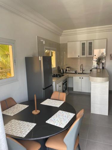 eine Küche mit Tisch, Stühlen und Kühlschrank in der Unterkunft Cité Soleil in Dakar
