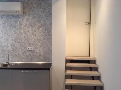 a staircase in a kitchen next to a sink at Apartahotel Baldiri in Sant Boi del Llobregat