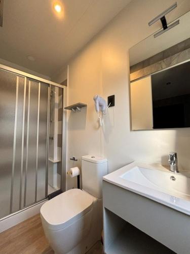 a white bathroom with a toilet and a sink at Camping Delfino in Albenga