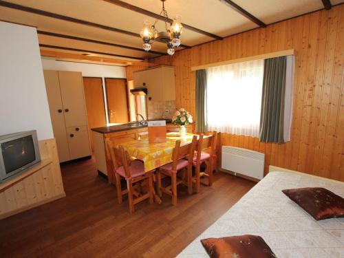 a dining room with a table and chairs and a television at Chalet in Valais near Ski Lift & Saas Valley in Saas-Balen