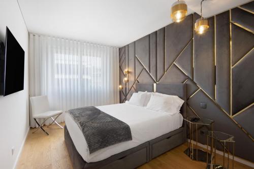 a bedroom with a large white bed and a wall at Uno del Mar 2 in Vila Nova de Gaia