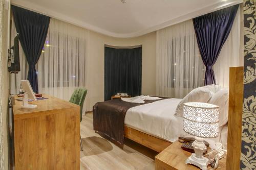 a bedroom with a bed and a desk with a computer at Newway Otel in Kayseri