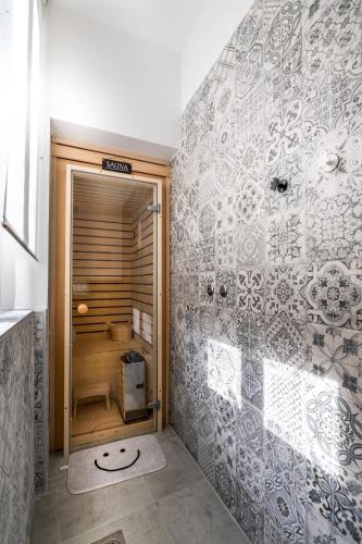 a bathroom with a walk in shower next to a wall at Apartment Grof Janko - Luxury in the Center - TERRACE & FREE PARKING in Karlovac