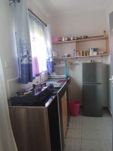 eine kleine Küche mit Herd und Kühlschrank in der Unterkunft Kitale Comfy in Kitale