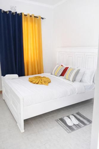 ein großes weißes Bett in einem Zimmer mit einem Vorhang in der Unterkunft Kitale Comfy in Kitale