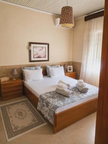 a bedroom with a bed with towels on it at Kikas Stone House in Ávaton