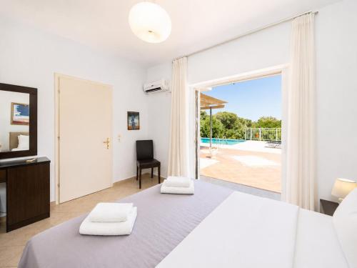 a bedroom with a bed and a view of a pool at Villa Peach in Katelios