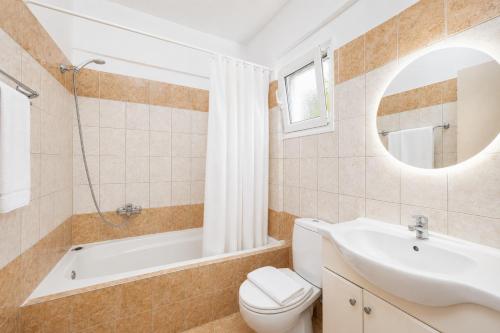 a bathroom with a tub and a toilet and a sink at Villa Peach in Katelios