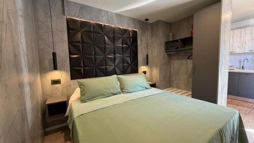 a bedroom with a large bed with a large headboard at Camping Delfino in Albenga