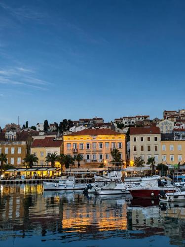 a group of boats docked in a harbor with buildings at Hotel Apoksiomen in Mali Lošinj