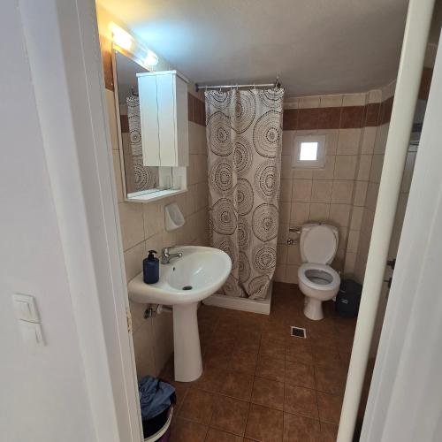 a small bathroom with a sink and a toilet at Soula appartments in Makry Gialos