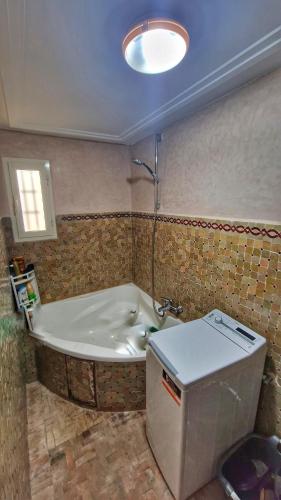 a bathroom with a bath tub with a shower at Tiguert serenity in Tiguert