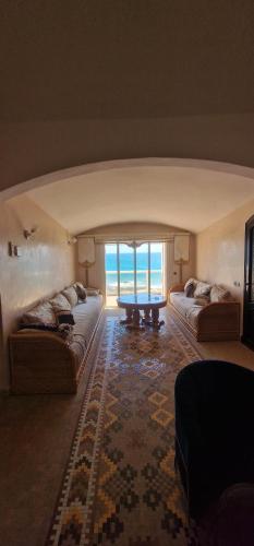 a living room with two couches and a table at Tiguert serenity in Tiguert
