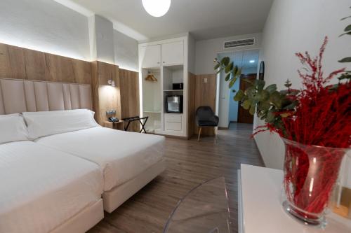 a bedroom with a bed and a vase of flowers on a table at Hotel Sercotel Doña Carmela in Seville