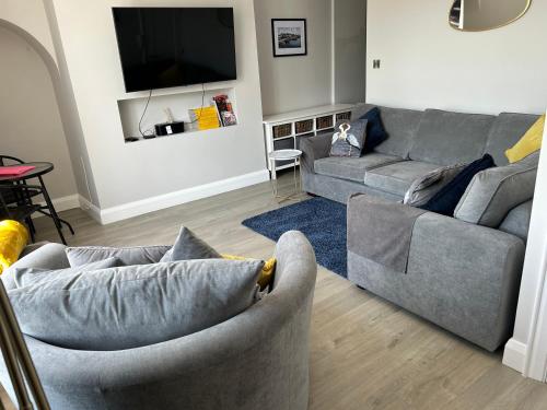 a living room with two couches and a tv at Seaview Aurora House - Central Luxury Apartment in Warrenpoint
