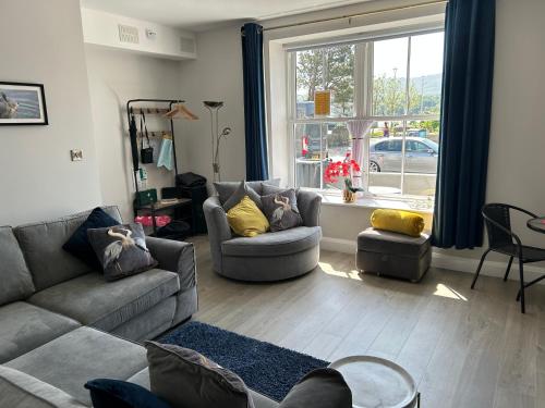 a living room with a couch and chairs and a window at Seaview Aurora House - Central Luxury Apartment in Warrenpoint