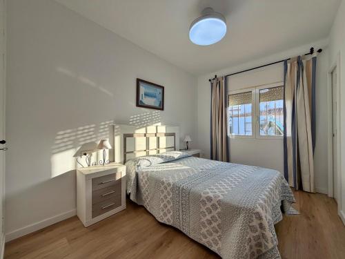 a white bedroom with a bed and a window at El Hidalgo Costa del Sol in Torre de Benagalbón