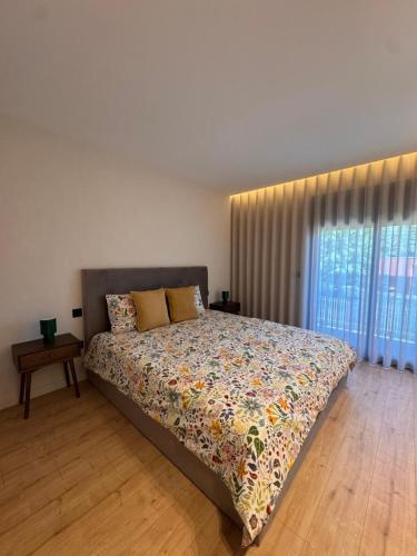 a bedroom with a bed and a window at Apartamento Cimo da Barca in Ponte da Barca