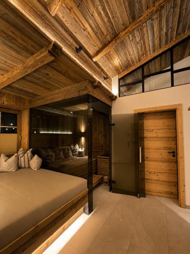 a bedroom with a large bed with a wooden ceiling at Das Weber in Sankt Jakob in Defereggen