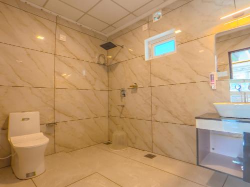 a bathroom with a toilet and a sink at Sky Dale Pool Resort Munnar in Munnar