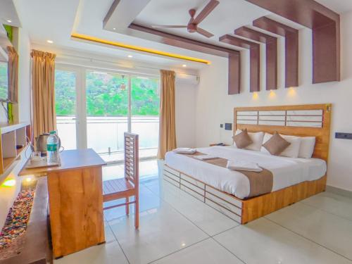 a bedroom with a large bed and a desk and a table at Sky Dale Pool Resort Munnar in Munnar