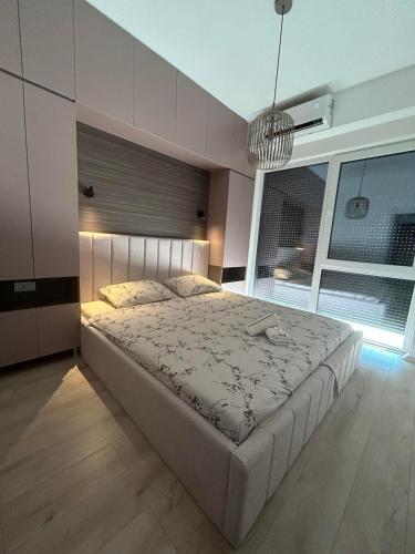 a bedroom with a large bed and a large window at Modern apartment with terrace in Petrovec in Petrovec