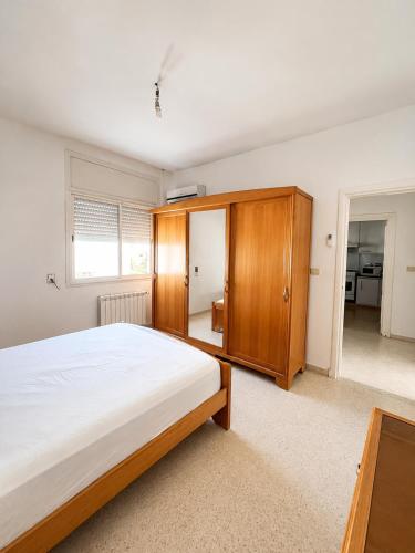 a bedroom with a bed and a wooden cabinet at Chic & Comfortable Stay in Monastir