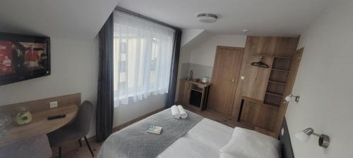 a bedroom with a bed and a desk and a window at Willa Wladek in Władysławowo