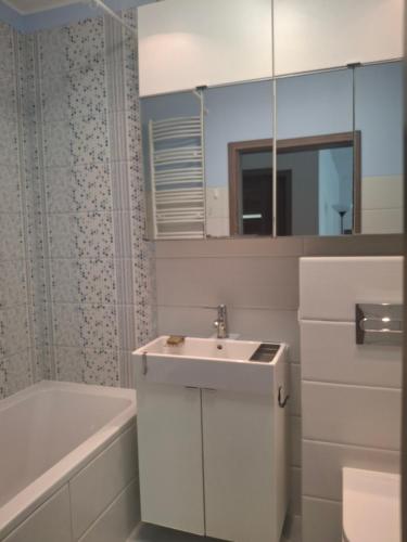 un bagno bianco con lavandino e vasca da bagno di Easy a Gdynia