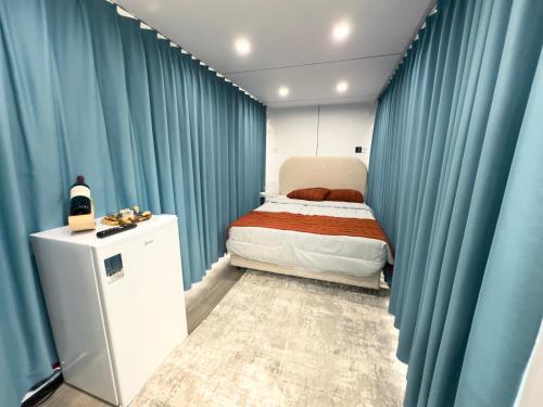 a small bedroom with blue curtains and a bed at Hotel Fazenda Parque dos Sonhos in Socorro