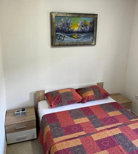 a bedroom with a bed and a picture on the wall at Eko Haus Tesla in Srnava