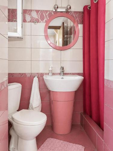 a pink bathroom with a sink and a toilet at Sady's House in Yimnón