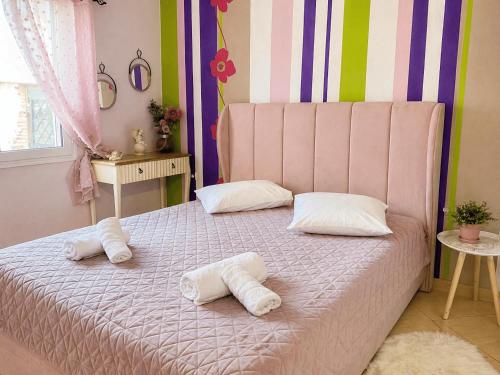 a pink bed with two white pillows on it at Sady's House in Yimnón