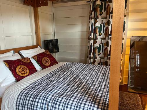 a bedroom with a bed with a checkered blanket at Coffee Mama Stay in Paramaribo
