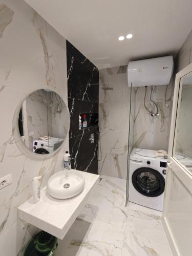 a bathroom with a sink and a washing machine at DfA in Tirana