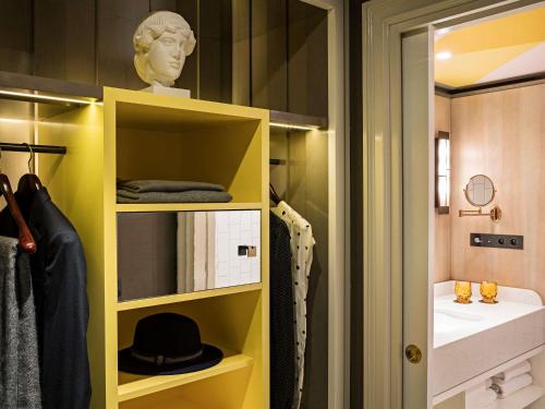 a bathroom with a yellow cabinet and a sink at Sofitel Le Scribe Paris Opera in Paris