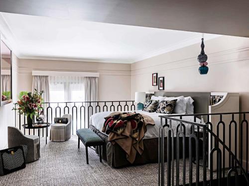 a bedroom with a large bed and a chair at Sofitel Le Scribe Paris Opera in Paris