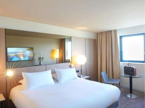 a large white bed in a hotel room at Pullman Bordeaux Lac in Bordeaux